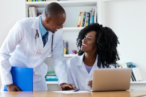 African american chief physician with young female doctor at work at hospital